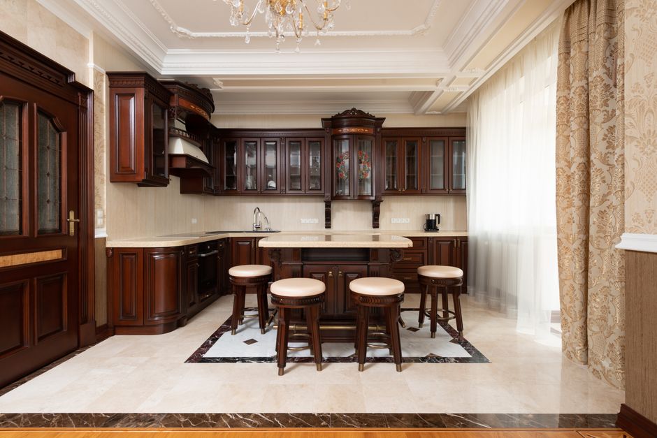 Spacious kitchen with dark wooden cabinetry and elegant decor, featuring a central island.