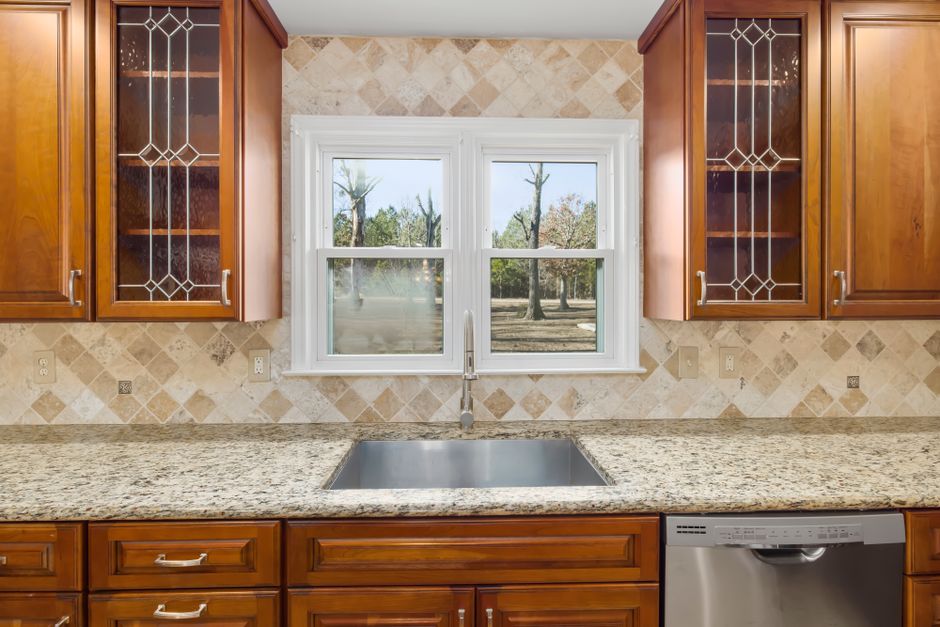 Sleek kitchen interior featuring wooden cabinets and a central window view.